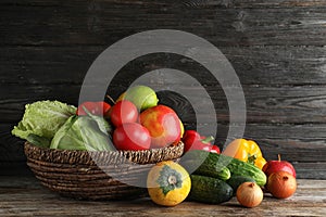 Basket with fresh fruits and vegetables on wooden table