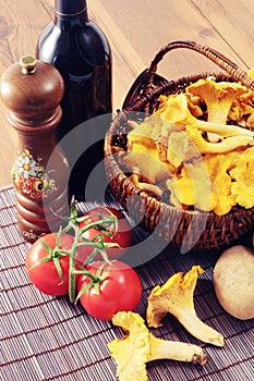 Basket with fresh golden chanterelles and potatos tomatos and re