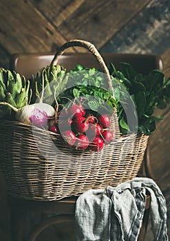 Basket of fresh organic garden vegetables and greens on chair