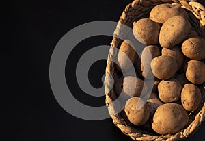 Basket of Fresh potatoes with dark background in the morning