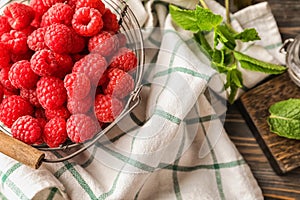 Basket with fresh ripe raspberries on table