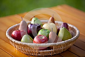 A basket of fruit with apples and pears