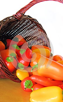 Basket Full of Colorful Peppers Spilling Out onto a Table