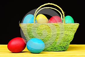 Basket full of colourful painted eggs for Easter