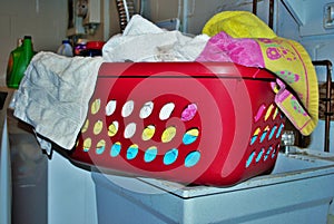 Basket full of dirty towels that need to be washed in a basement laundry room
