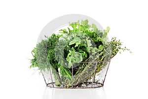 Basket full of fresh herbs isolated on white