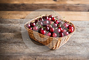 A basket full of freshly picked cherries on a wooden table.. AI generated.
