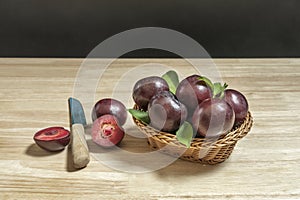 A basket full of ripe red plums