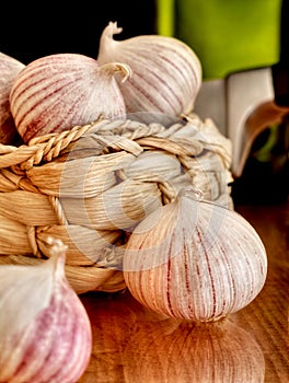 Basket of garlic, oil and knife on a table