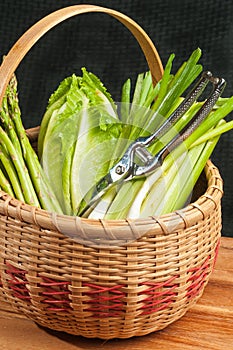 Basket of green vegetables and stainless scissors