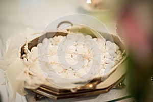 A basket of jordan almonds await guests at a wedding ceremony