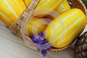 Basket of Korean Melons With Purple Flowers and Pineapple