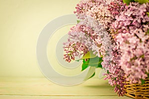 Basket of lilac pink flowers on blue background photo