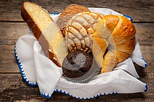 Basket with Mexican sweet breads on a wooden background photo