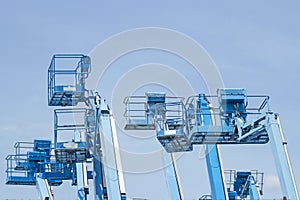 Basket of multiple forklifts are old of blue on blue sky background