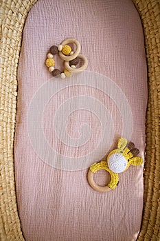 in a basket natural wooden knitted toys for a newborn. View from above