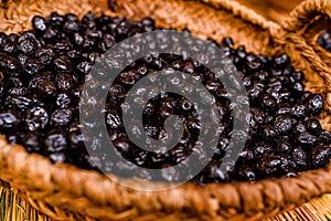 Basket with nutritious dried black olives, snack typical of the Mediterranean countries