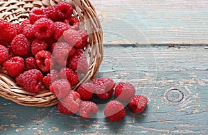 Basket of raspberries on a turquoise wooden table