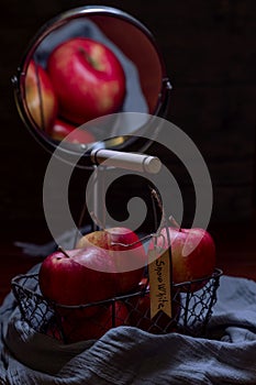 A basket of red apples with the inscription Snow White is reflected in a mirror, recreating the atmosphere of the fairy tale