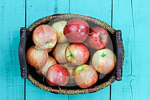 Basket of red apples sitting on wood table
