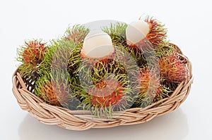 Basket of red hairy rambutan fruits.