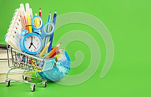 Basket with school supplies on a green background. Back to school concept. Purchase of school supplies. Baner. Copy space