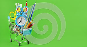 Basket with school supplies on a green background. Education concept. Back to school. Baner. Copy space