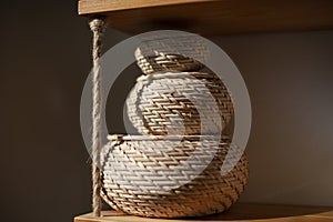 Basket for small things. Object in interior. Braided box is rounded in shape. Sunlight on object in room
