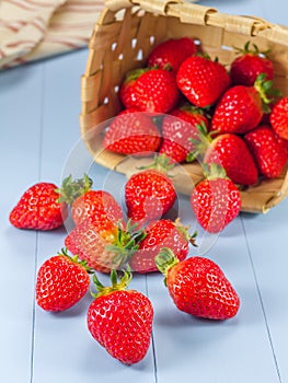 Basket with strawberries spilling on a table