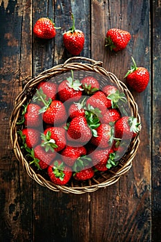 Basket of strawberries on wooden table. Generative AI