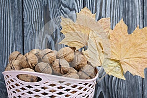 Basket with walnuts. Dried maple leaves. Harvesting a new crop