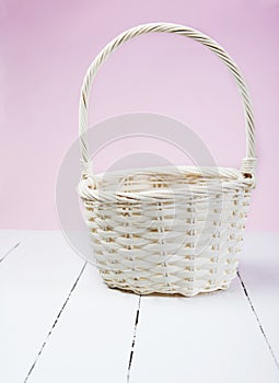 Basket on white wood with pink background