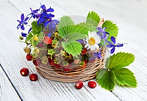 Basket with wild strawberries and wildflowers
