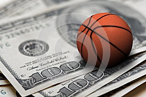 Basketball ball on 100 dollars bills closeup photo