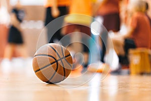 Basketball Ball On Hardwood Floor Youth Basketball Team in Background