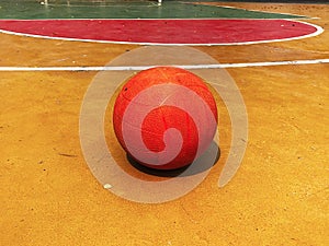 A basketball ball is placed on a basketball court