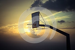 Basketball basket against sunset sky