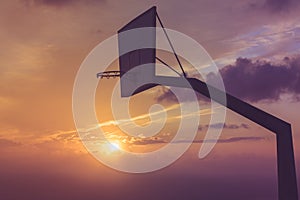 Basketball basket against sunset sky