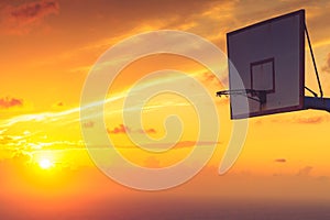 Basketball basket against sunset sky