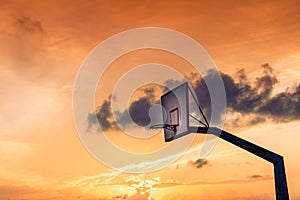 Basketball basket against sunset sky