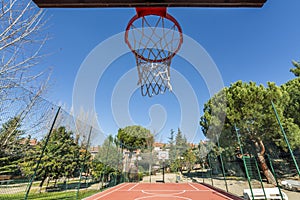 A basketball basket on a court with artificial floor surrounded
