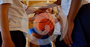 Basketball coach and schoolkids forming hand stack in the basketball court 4k