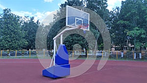 The basketball court is arranged on the rubberized surface of the stadium. Basketball backboard with hoop and basket is fixed on t