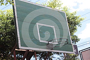 The basketball court is housed in a ring that has a net and is supported by a pole with a board on the rear.