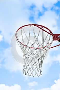 Basketball goal with blue sky and clouds