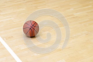 Basketball on hardwood court floor with natural lighting. Workout online concept. Horizontal sport theme poster, greeting cards, h