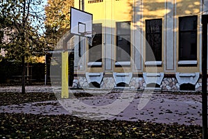 Basketball hoop in the backyard of a school at sunset