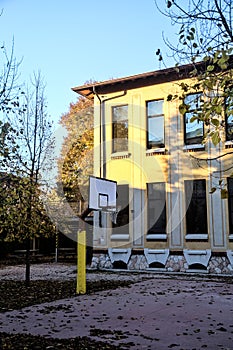 Basketball hoop in the backyard of a school at sunset