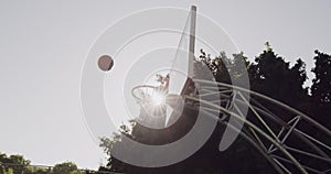 Basketball, hoop and court in net at park for outdoor game, shot or score for point or match. Ball flying high in air