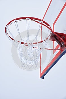 Basketball hoop with net, covered by hoarfrost